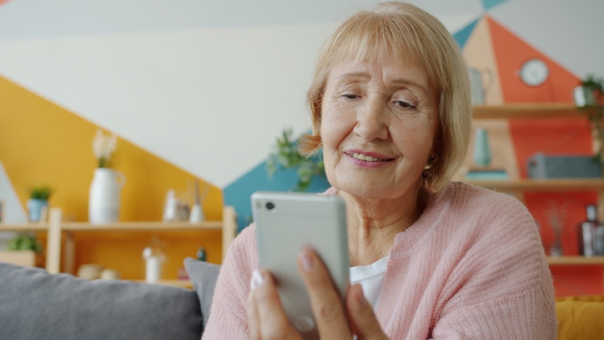 A happy older woman laughing on her morning check-in call