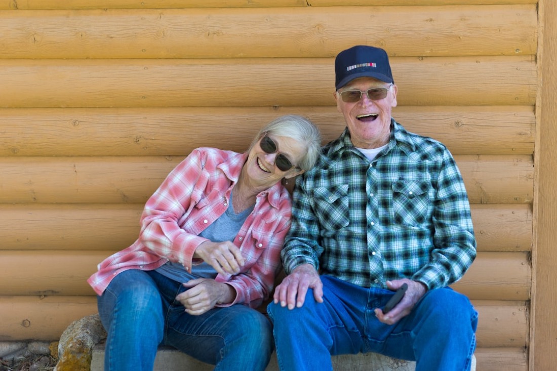 A cheerful older couple laughing together outdoors